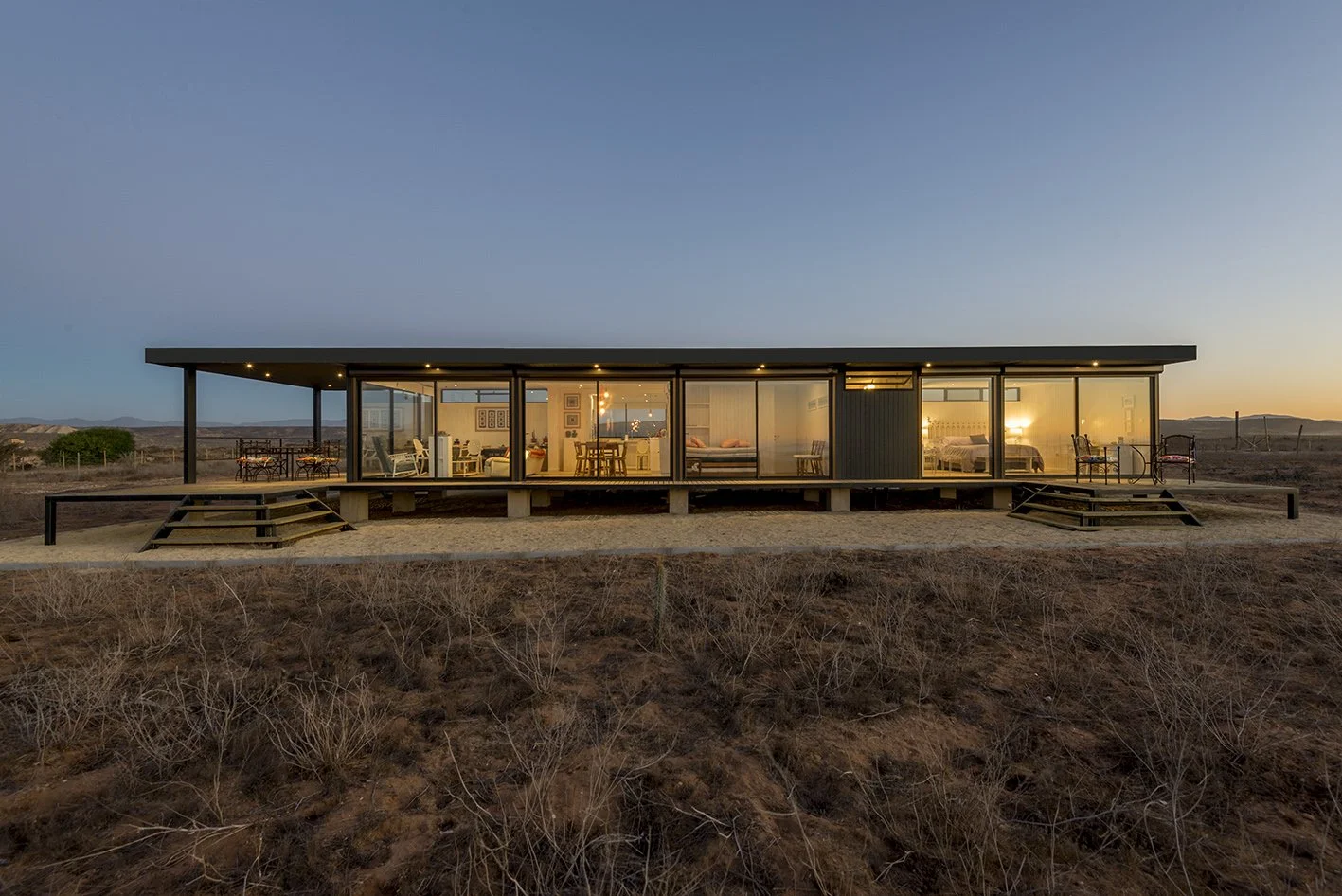 Casa modular contemporánea con grandes ventanales y exterior de madera.